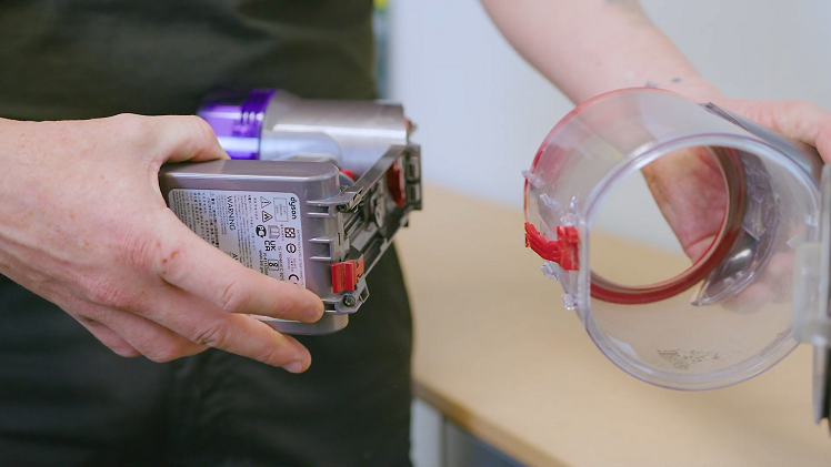 Remove the bin by pushing the red clip at the bottom of the bin, then pull the bin away.