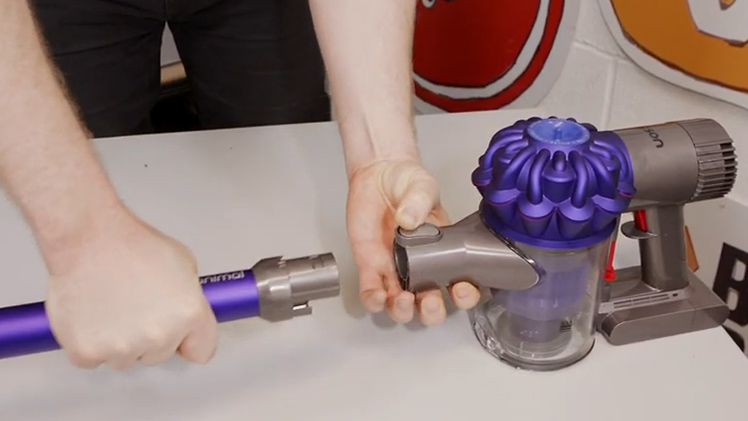 Press down on the grey release button and pull the wand away