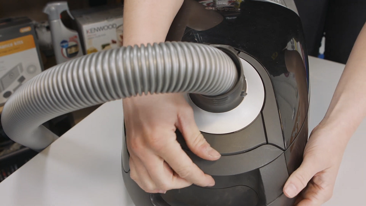 Open the vacuum cleaner cover by pulling on the release hatch at the front to access the bag