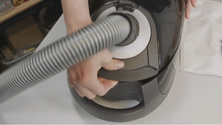 Open the vacuum cleaner cover by gently pulling on the release catch at the front
