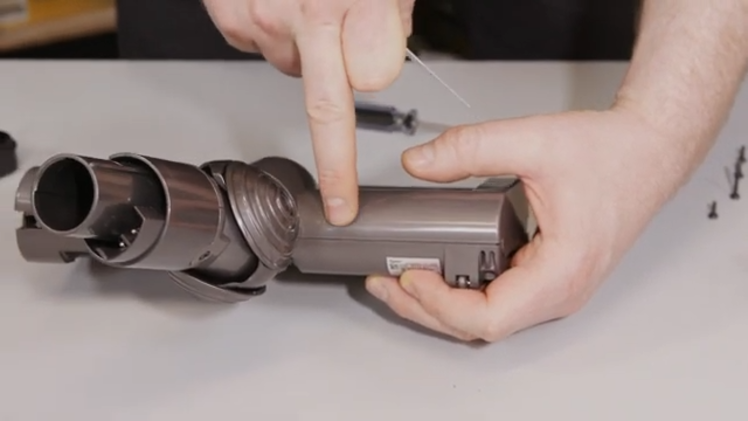 Use a thin card to wedge between the upper and the lower housing and disengage the catch that holds it together
