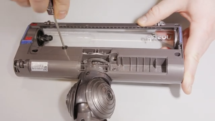 Remove the upper housing of the motorhead by removing five screws. Four of these are small ones located at each corner of the motorhead and the fifth is a long one near the middle