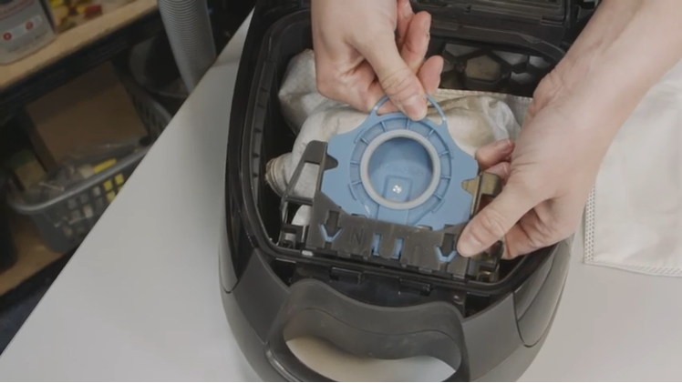 Remove the old vacuum bag by holding onto the bag holder mount with one hand and pulling on the top seal handle with the other