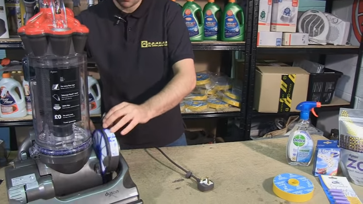 Remove the pre-motor filter housing from the side of the vacuum cleaner