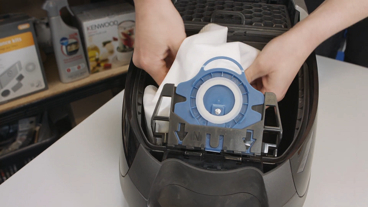 Tuck the vacuum bag securely into the vacuum cleaner before closing the cover
