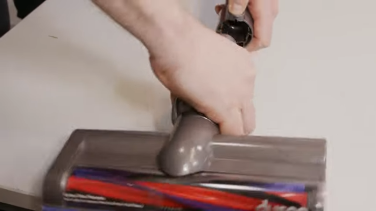 Disconnect the motorhead from the wand by pushing down on the grey button and gently pulling it away
