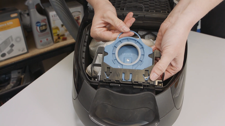 Remove the old bag by holding onto the bag holder mount with one hand and pulling on the top seal handle with the other